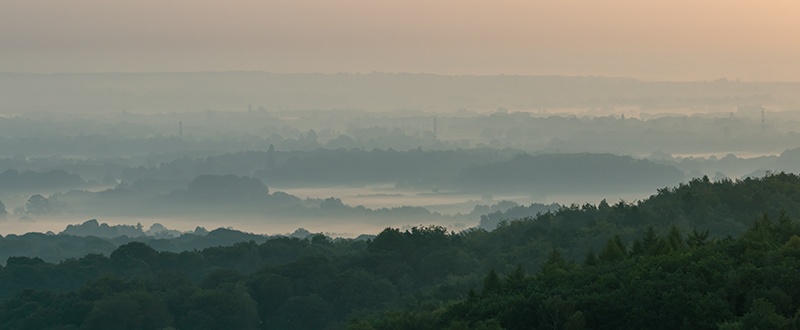 View from Bradgate park looking down onto Cropston, a warm foggy morning. The sun has just begun to rise.