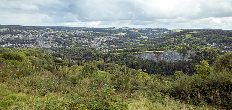 A nice view of Matlock. Green hills and a significant cliff in the foreground